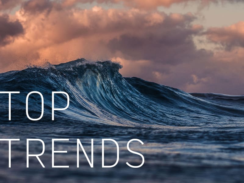An ocean wave during a cloudy sunset with the caption "Top Trends".