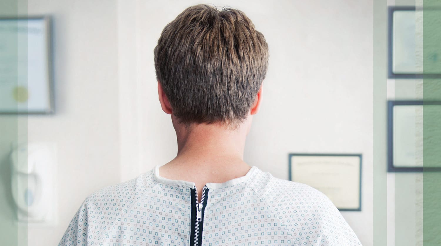 A back view of a man in a medical gown.