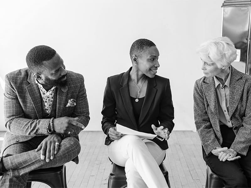 Three professionals sitting and talking.
